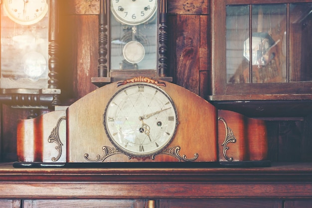 Collectible varieties of antique clocks hanging on the wall or placing on wooden cabinet