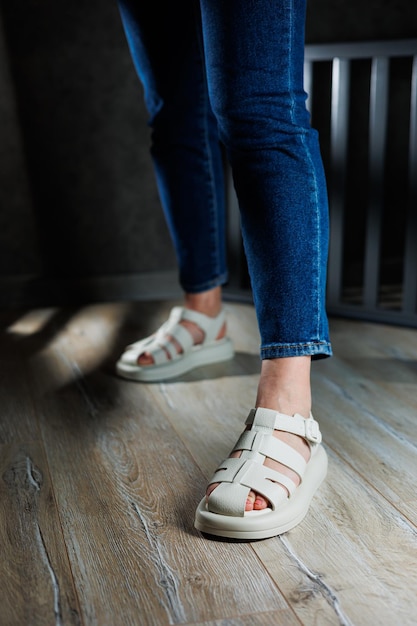 Collectie leren zomersandalen voor dames Slanke damesbenen in beige leren sandalen zonder hak