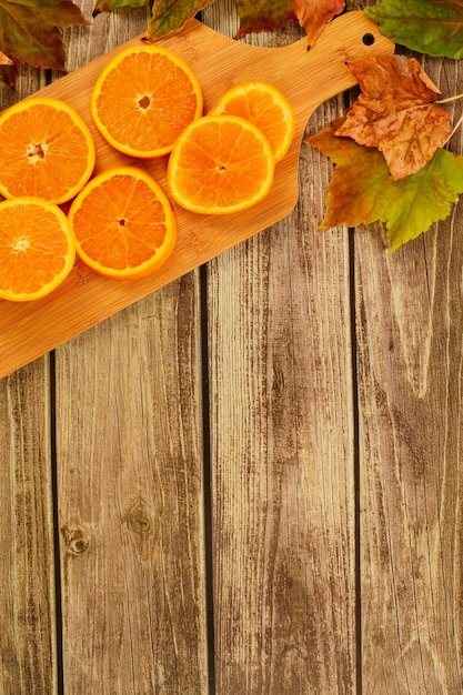 Collectie prachtige kleurrijke herfstbladeren en stukjes sinaasappel op houten achtergrond