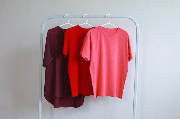 Collectie t-shirts met rode kleurenvariant die aan een kledingrek hangen