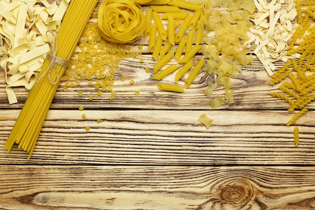 Foto collectie van italiaanse pasta bovenaanzicht op vintage houten achtergrond.