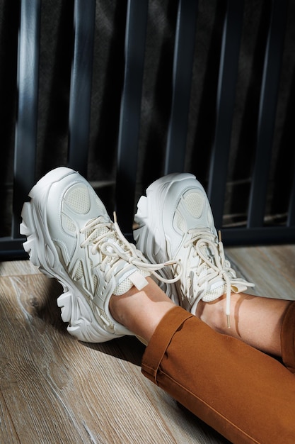 Collectie zomer leren sneakers voor dames Close-up van vrouwelijke benen in witte sneakers Dames zomersneakers met veters