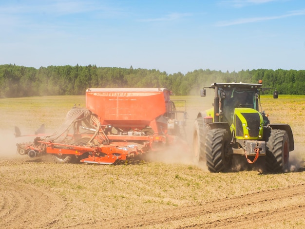 Collectieve boeren zaaien zaaien gewassen in het veld grote tractor werken in het veld oogsten zaken doen landbouw bodemvoorbereiding voor aanplant