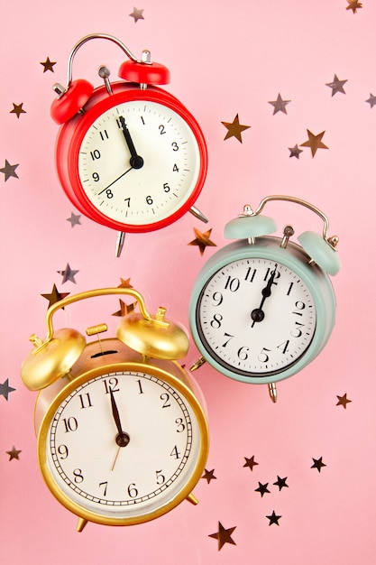 Collection of bright colorful alarm clocks over the pink background