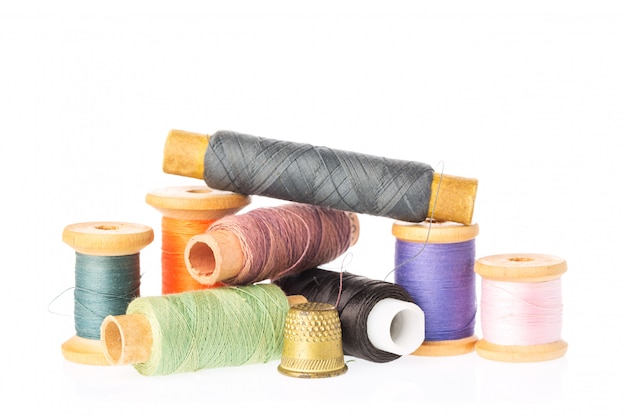 Collection of color thread spools with thimble isolated on white 