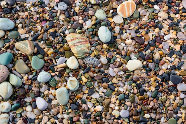 Коллекция разноцветных камушков на пляже.