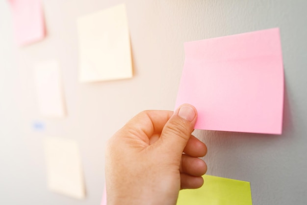 collection of colorful variety post it paper note reminder sticky notes pin paper blue on cork bulletin board empty space for text
