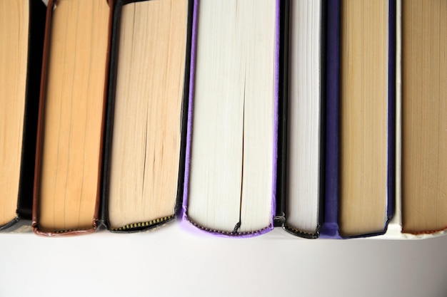 Collection of different books on white shelf top view