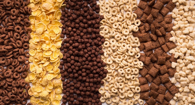 Collection of different cereals and flakes background, top view