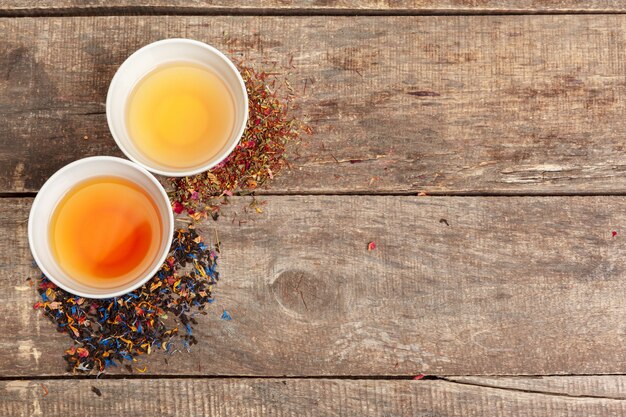 Collection of different teas in cups with tea leaves 