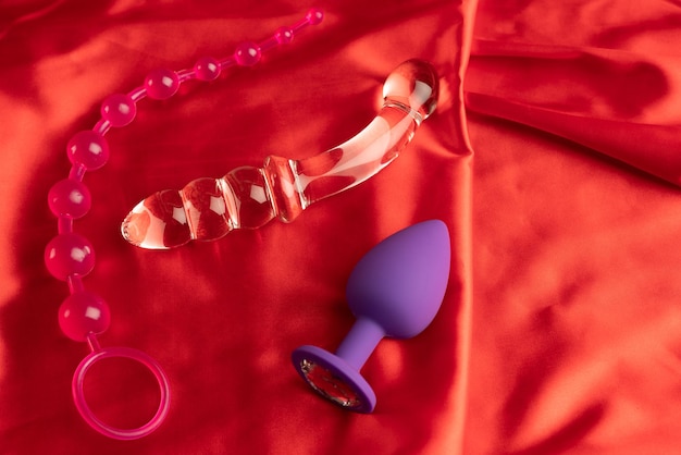 A collection of different types of sextoys on red satin