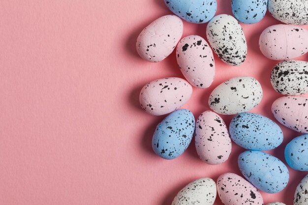 A collection of easter eggs on a pastel pink background