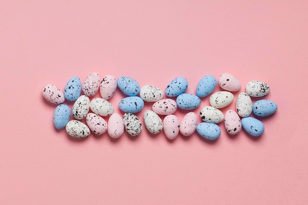 A collection of easter eggs on a pastel pink background