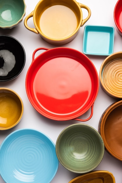 Collection of empty colorful ceramic bowls. Group of utensils captured from above, top view, flat lay against white background