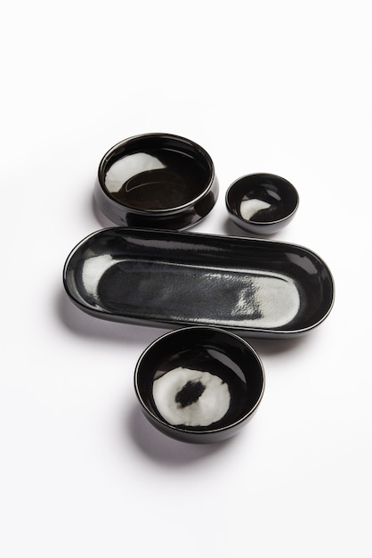 Collection of empty colorful ceramic bowls. Group of utensils captured from above, top view, flat lay against white background