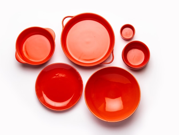 Collection of empty colorful ceramic bowls. Group of utensils captured from above, top view, flat lay against white background