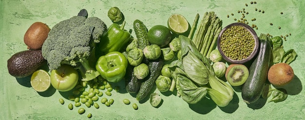 Collection of fresh green vegetables Broccoli zucchini asparagus beans brussels sprouts kiwi avocado apple