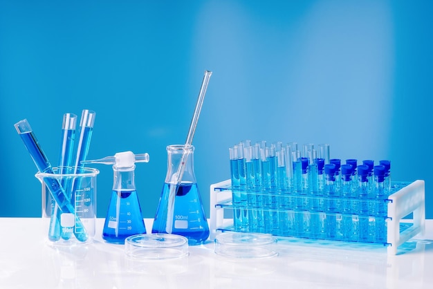 Collection of medical flasks on a blue backgroundScience glass flask blue chemistry laboratory