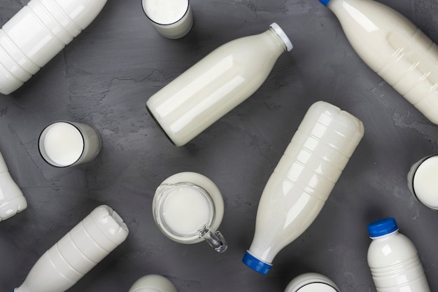 Collection of milk bottles on gray stone background, top view