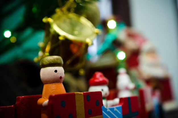 クリスマスの季節を祝うために小さなクリスマスツリーの下にあるミニチュアの木製のおもちゃのコレクション