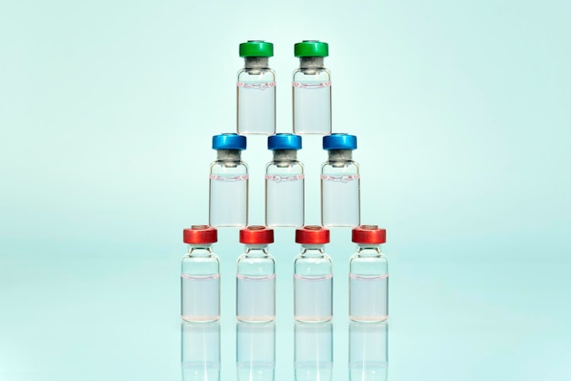 A collection of multipurpose transparent bottles with colored caps standing and arranged and on blue background pharmacology products