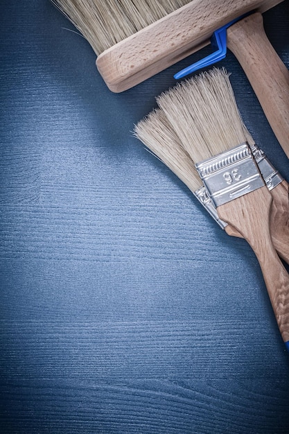 Collection of paint brushes on wood board construction concept