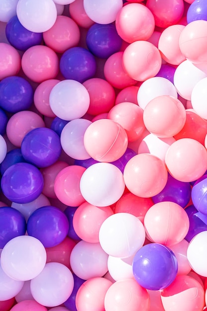 Collection of pink purple and white balls in a box