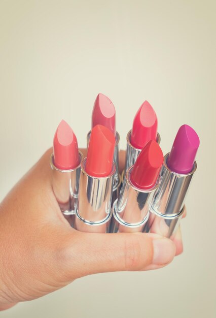 Collection of puple pink and red shiny lipsticks in hand retro toned