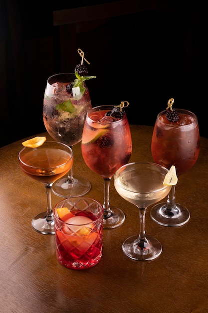 Collection of refreshing cocktail glasses at party lillet spritz aperol with lemon red fruits and negroni mint and ice