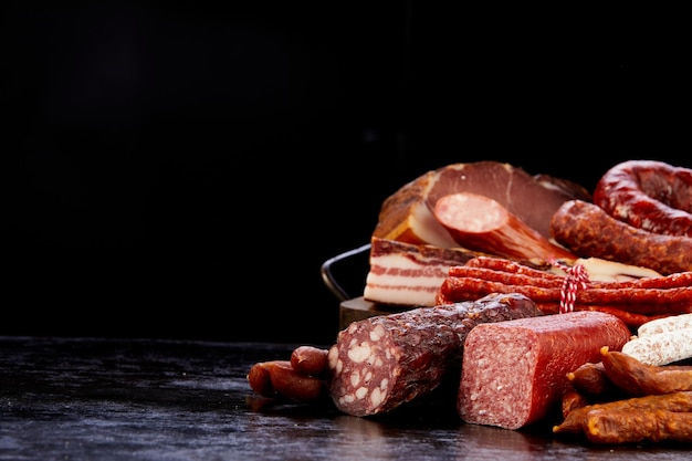 Collection of sausages on black table