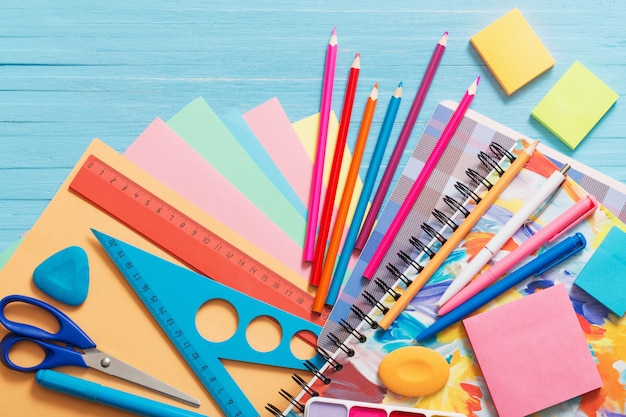 Collection of school supplies on blue wooden table