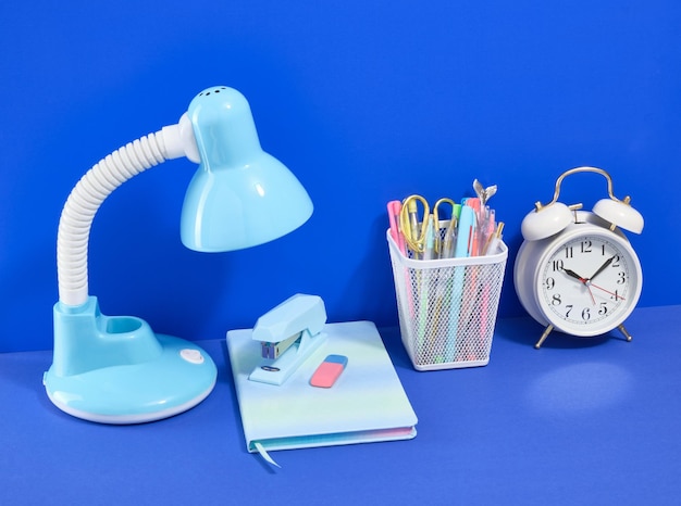 Collection of school supplies and education concept Retro alarm clock desk lamp and stationery