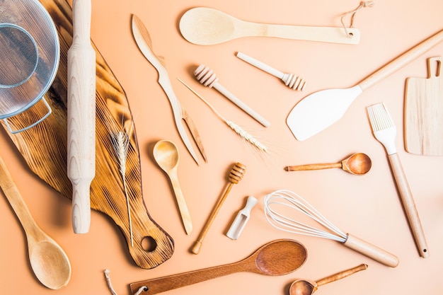 A collection of various kitchen utensils for cooking on a brown background top view flat styling environmentally friendly items