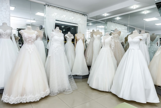 Collection of wedding dresses in showcase of the shop