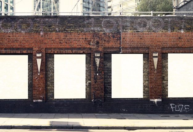 Collection of white posters on brick background in modern city