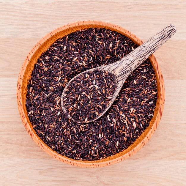 Collection of whole grain jasmine rice on wooden table .