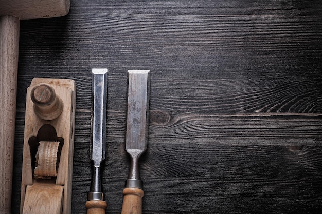 Collection of wooden mallet chisels shaving plane on wood board