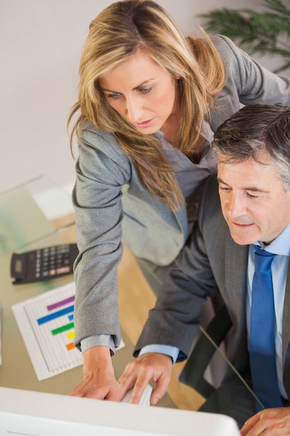 Collega&#39;s die een computer in een bureau kijken