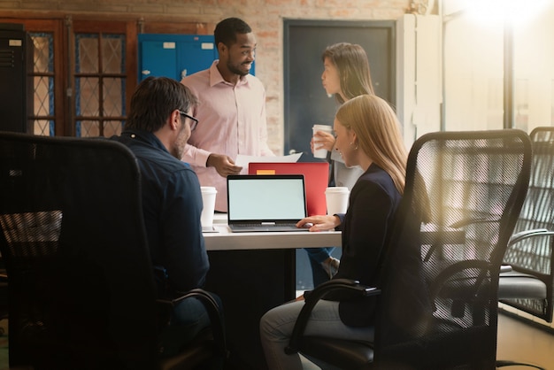 Collega&#39;s die werken in moderne kantoorruimte