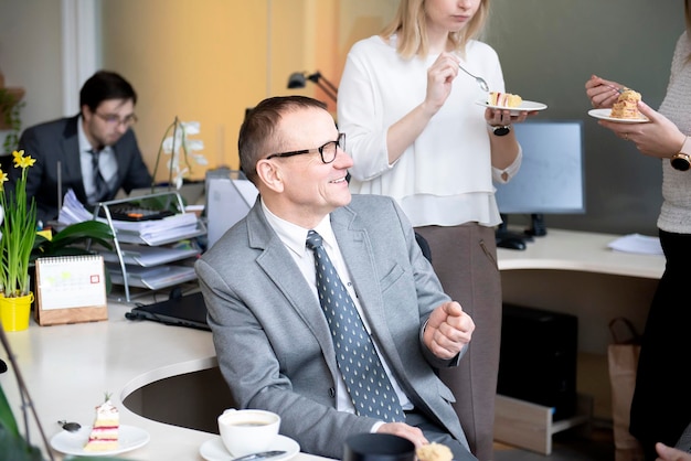 Foto collega's hebben een koffiepauze in het kantoor aan hun bureau