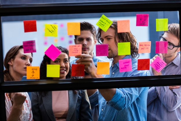 collega's lezen een post-it op een raam