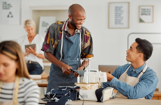 Collega's van modeontwerpers en mannen die kleding naaien in een werkplaats Gelukkige diverse en lachende jonge creatievelingen die kledingontwerpen plannen in een textielkleding- en productiestudio of fabriek