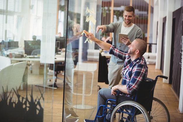 Collega van de zakenman de bijwonende handicap in creatief bureau