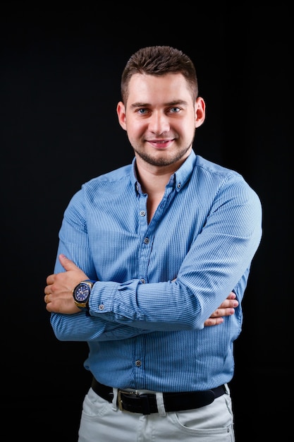 Collega-zakenman in blauw shirt en witte broek op een zwarte achtergrond