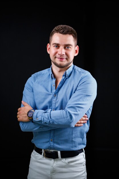 Collega-zakenman in blauw shirt en witte broek op een zwarte achtergrond