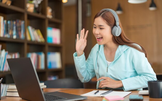 대학 교육 개념 10대 소녀는 학습 튜토리얼 후 친구들과 화상 통화를 하기 위해 노트북을 사용합니다.