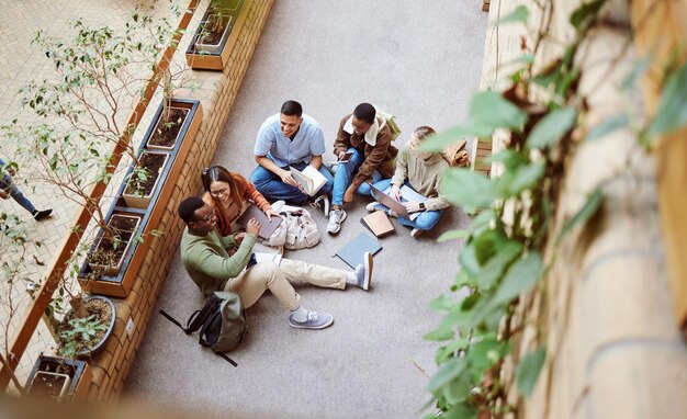 Foto college groepssamenwerking en diversiteit studenten die werken aan onderzoeksuniversiteitsproject of onderwijsstudie kennis leren studiebeurs teamwork en bovenaanzicht van ontspannen mensen op schoolcampus