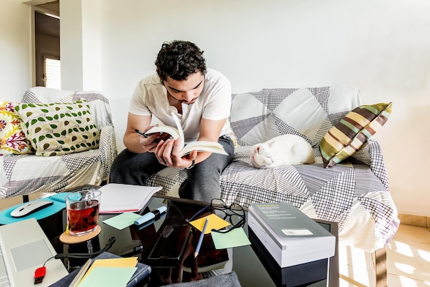 Photo college guy studying doing homework at living room