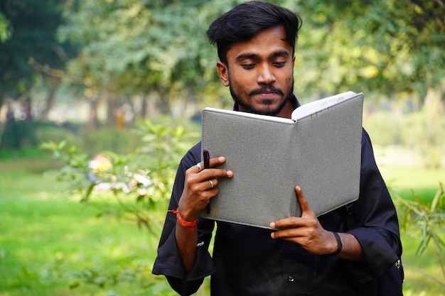 College student near college campus with books reading books concept