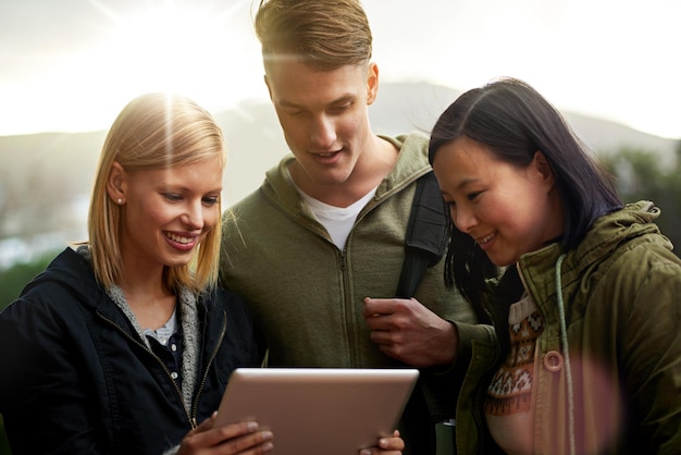 Foto college vrienden en gelukkig met tablet buiten voor onderzoek ontspannen of breken op de campus met sociale media universiteit mensen en glimlachen met technologie voor internet streaming of leren met zonlicht